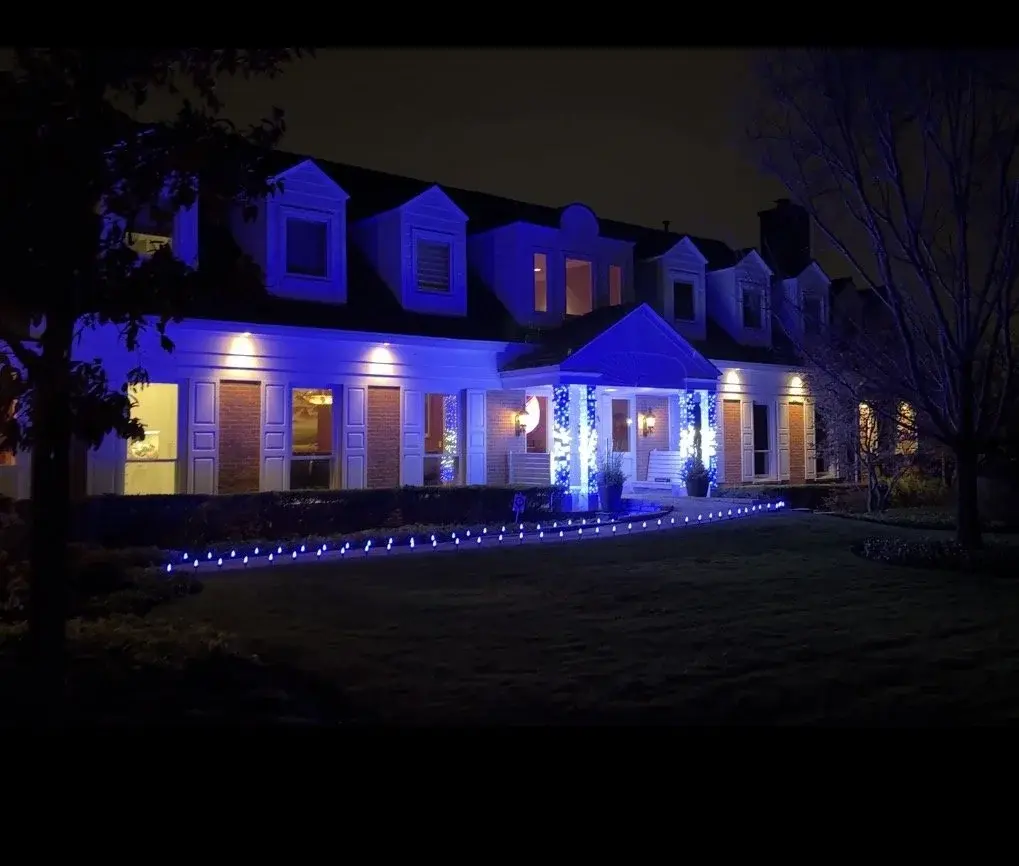 Estate home in blue holiday lighting